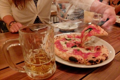 ピザを食べ、暴飲暴食する女性