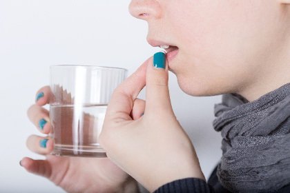 薬を飲んでいる女性の写真