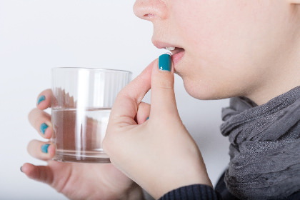 薬を飲んでいる女性の写真