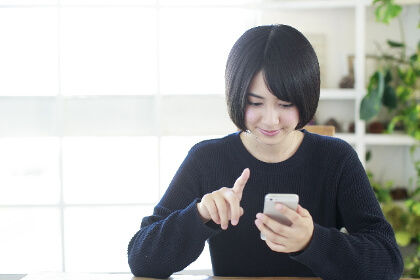 スマホを使う女子高校生の写真
