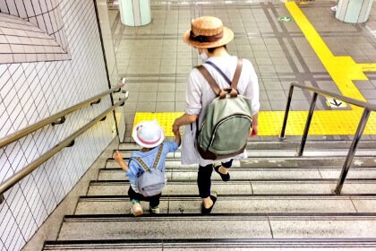 階段を子どもと一緒に降りる女性